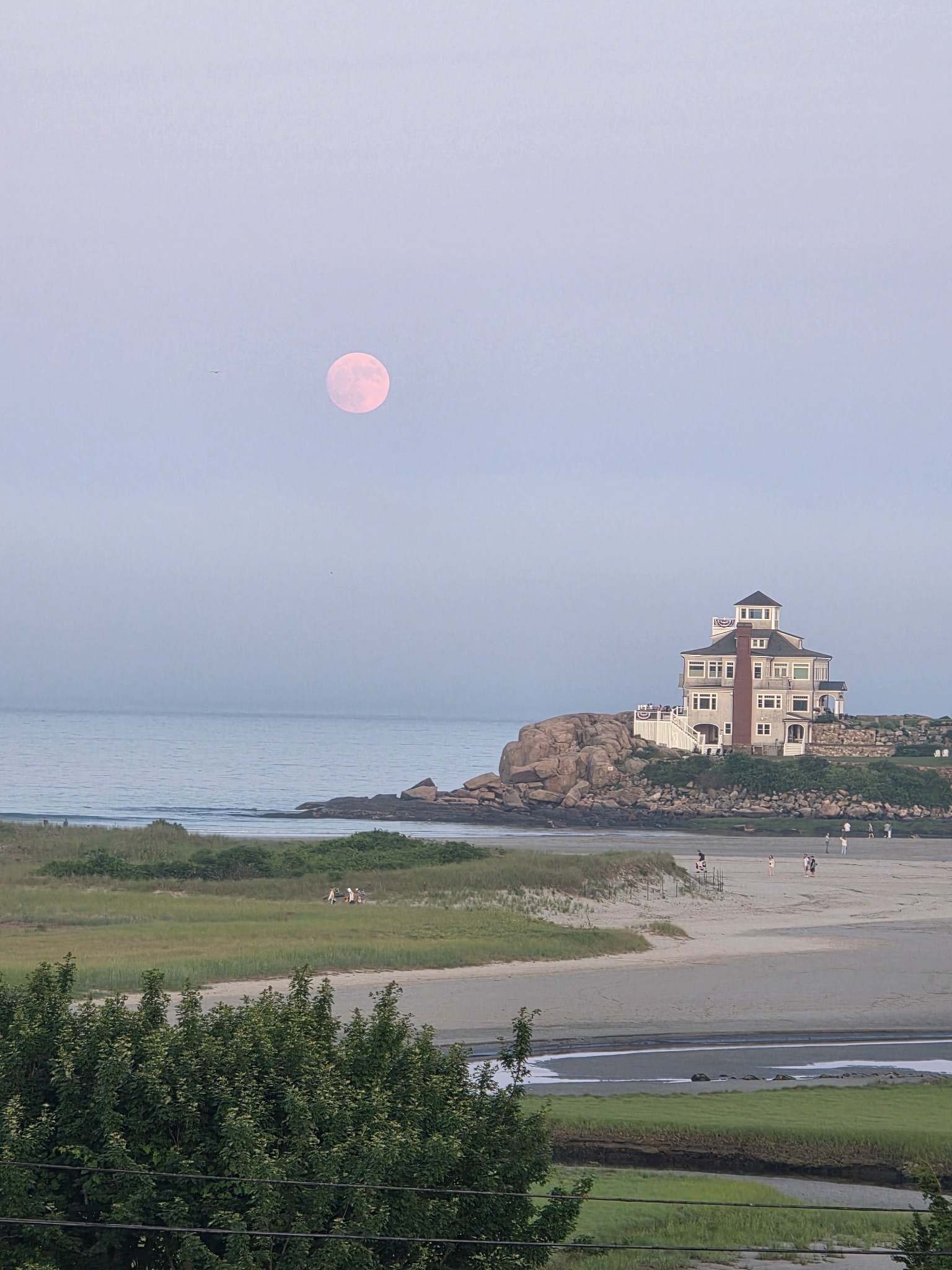 Moonrise over the Gloucester shoreline, beach, rocks, and water