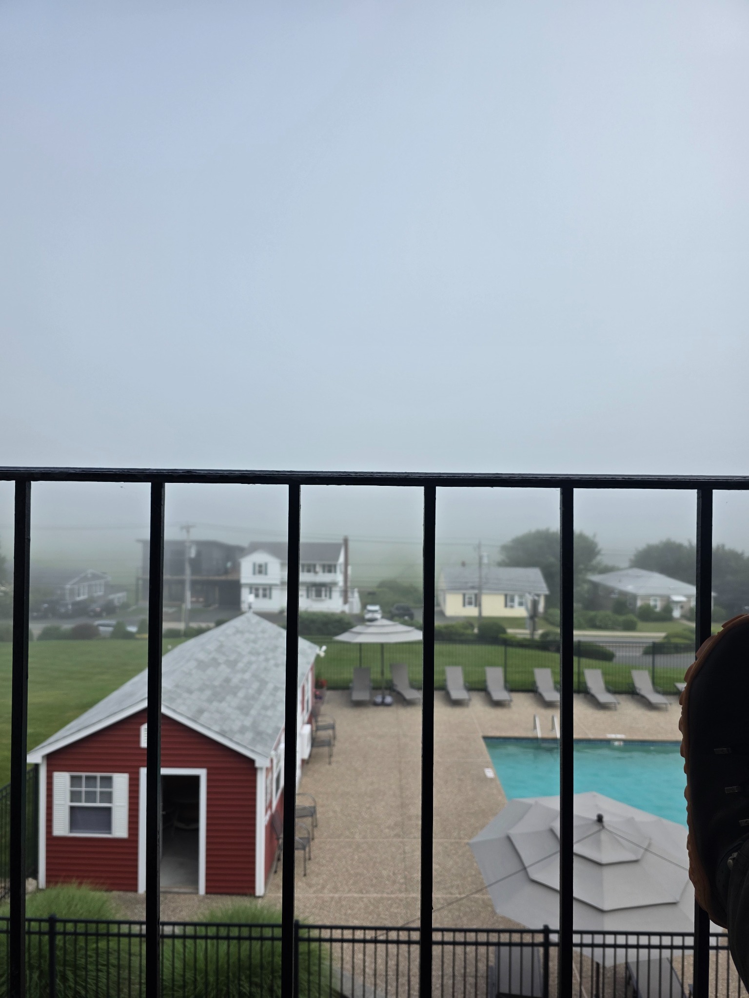 Sea fog obscuring the bay beyond the hotel pool in Gloucester, Massachusetts